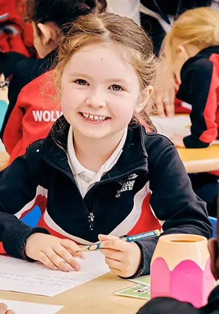 Junior School child smiling at her desk